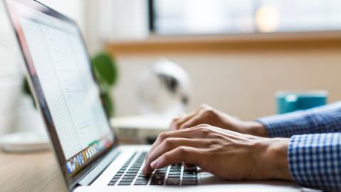 Primer plano de las manos de un hombre usando una laptop