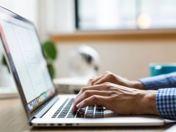 Primer plano de las manos de un hombre usando una laptop
