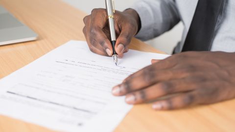 Foto referencial de un hombre firmando unos documentos