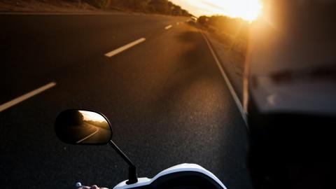 Foto del una carretera al atardecer tomada por el conductor de una motocicleta