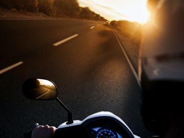 Foto del una carretera al atardecer tomada por el conductor de una motocicleta