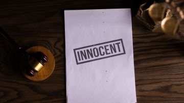 Foto referencial de un escritorio de juzgado con un veredicto de inocente