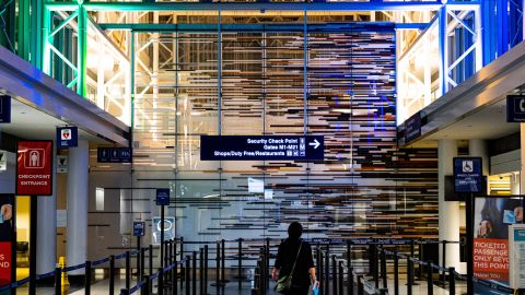 Foto de una mujer caminando hacia el espacio de confirmación de un aeropuerto