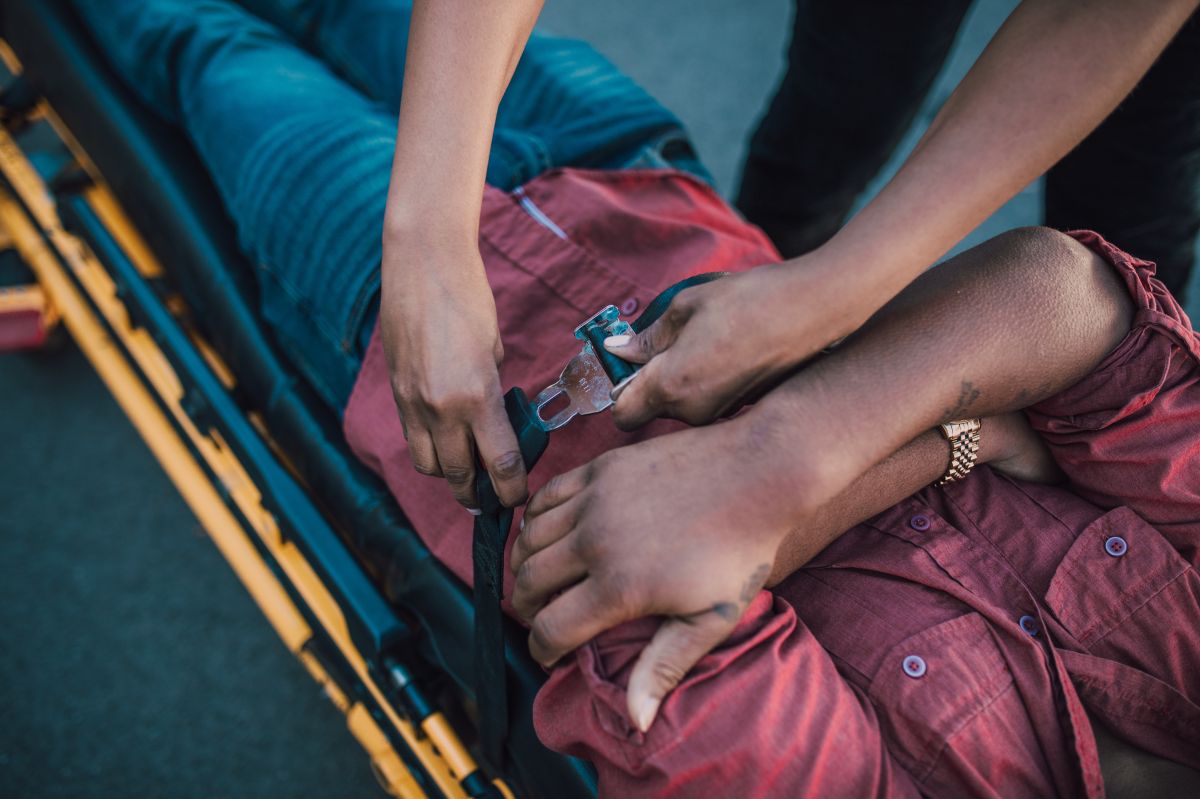 Foto representativa de un paramédico inmovilizando a un lesionado en una camilla