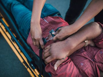 Foto representativa de un paramédico inmovilizando a un lesionado en una camilla
