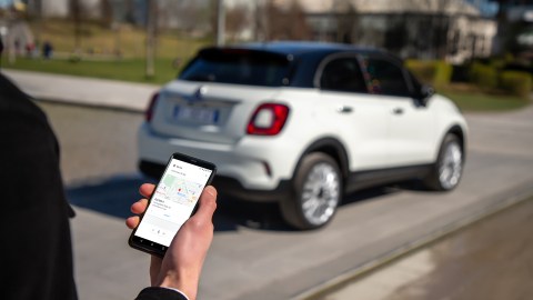 Foto de un usuario usando su celular para comunicarse con su Fiat 500 "Hey Google"
