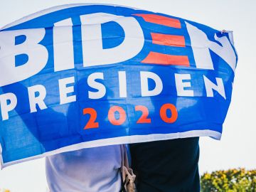Fotos de una pancarta en apoyo a Biden sostenida por dos personas