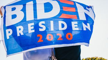 Fotos de una pancarta en apoyo a Biden sostenida por dos personas