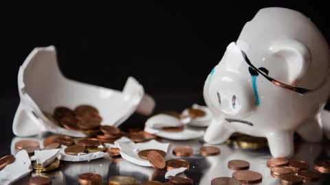 Foto de una alcancía rota mostrando el dinero
