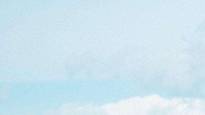 Foto de un Volkswagen escarabajo amarillo con una tabla de surf a la orilla del mar