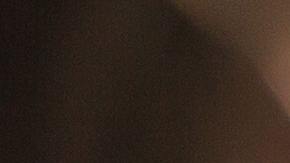 Foto de una mujer mientras conduce tomada desde el asiento de atrás.