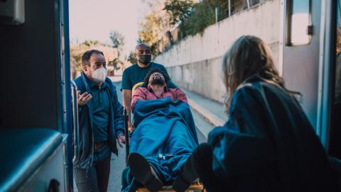 Foto de un herido sobre la camilla siendo transportado al interior de una ambulancia