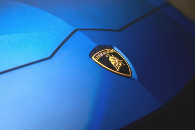 Primer plano del símbolo de Lamborghini en un auto color azul