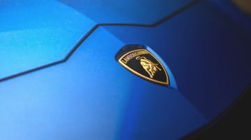 Primer plano del símbolo de Lamborghini en un auto color azul