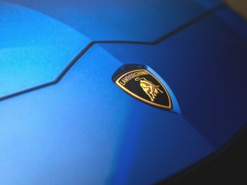 Primer plano del símbolo de Lamborghini en un auto color azul