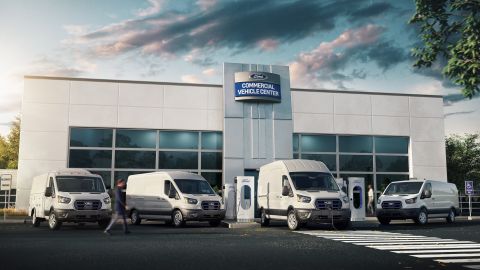 Foto de la línea de furgonetas E-Transit de Ford estacionadas frente a un centro de servicio