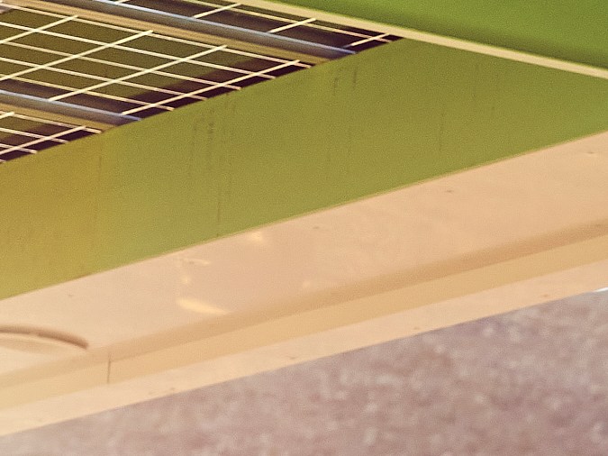 Foto de una estación de carga Electrify America con una SUV roja en segundo plano