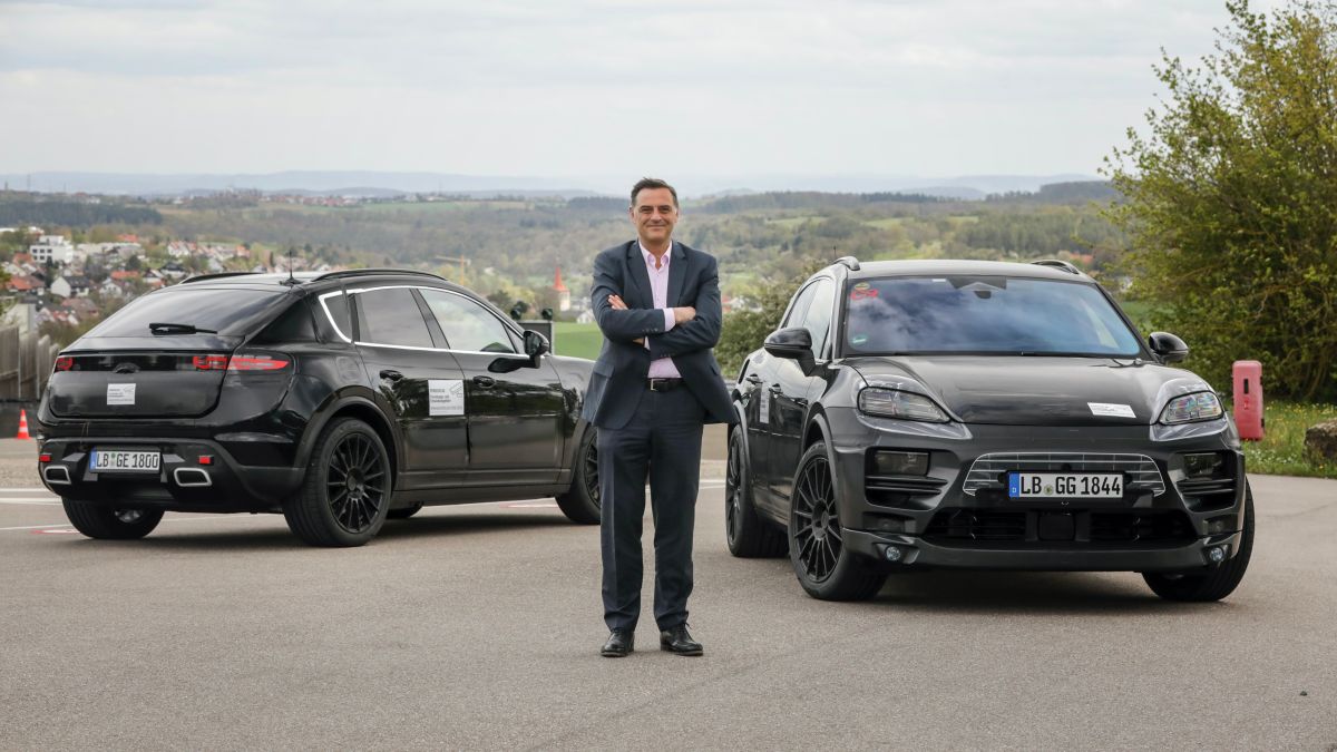 Foto del Michael Steiner, encargado de Investigación y Desarrollo, junto a los prototipos del Macan eléctrico