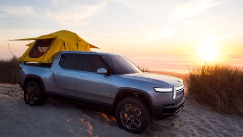 Foto de la camioneta eléctrica R1T de Rivian con una tienda de campaña en la zona de carga