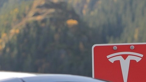 Foto de una estación de carga Tesla con un Model X cargándose