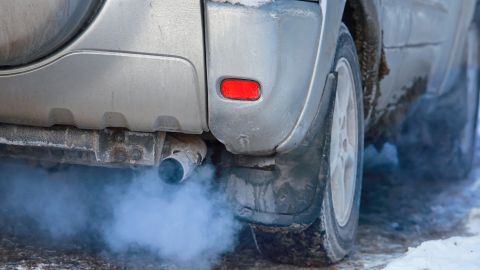 Auto expulsando humo azul por el mofle