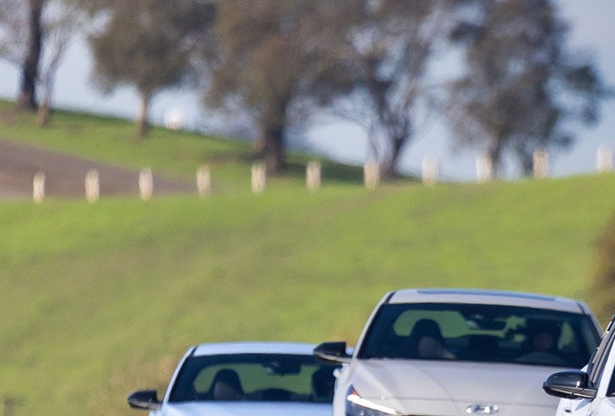 Un Hyundai Kona N seguido de dos Elantra N en la pista de carreras de Sonoma, California.