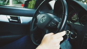 Foto de la mano de una persona sobre el volante de un auto
