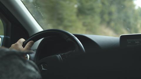 Foto de la mano de una persona sobre el volante
