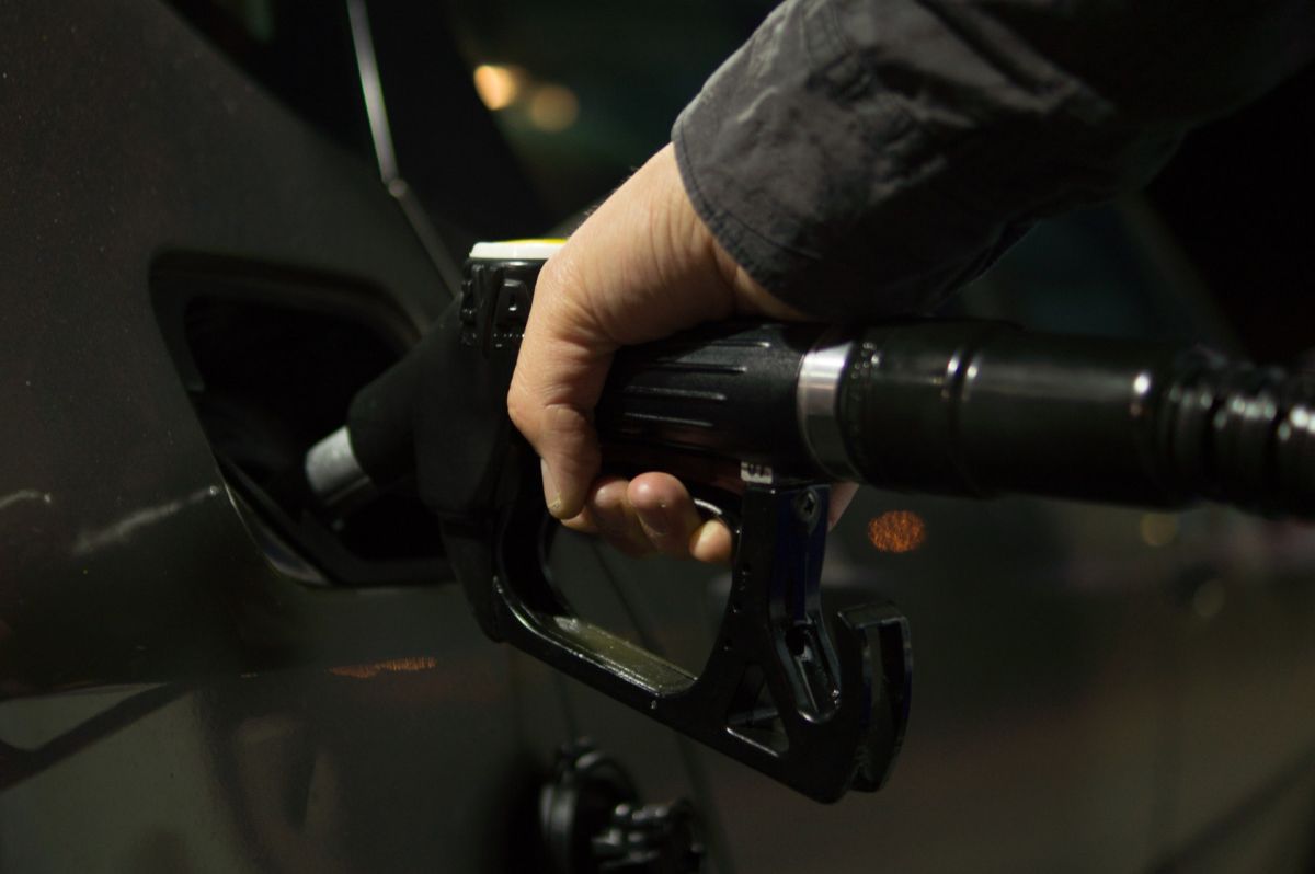 Foto de la mano de una persona poniendo gasolina en una estación