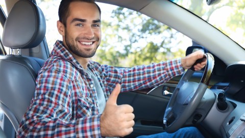 Foto de un conductor sonriendo con el pulgar hacia arriba