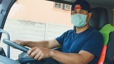 Foto de un conductor al volante con una mascarilla