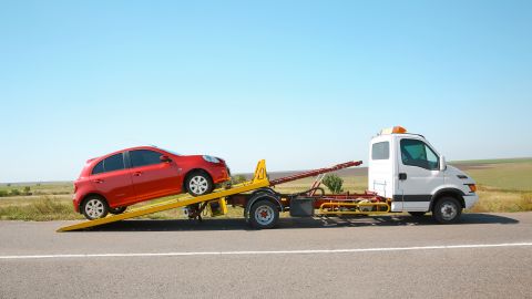 Foto de una grúa remolcando un vehículo en la carretera