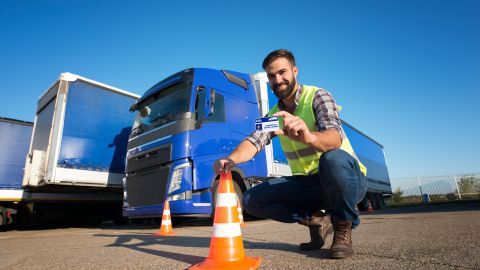 Foto de un conductor de camiones mostrando su licencia de conducir