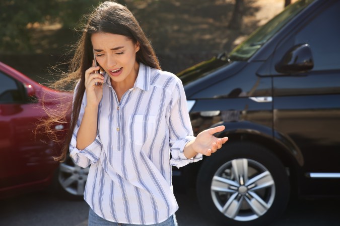 Foto de una mujer hablando por teléfono luego de un accidente de tránsito