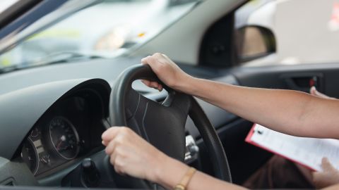 Fotos de las manos de una persona sobre el volante mientras está en una prueba de manejo