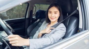 Foto de una mujer sonriendo mientras conduce
