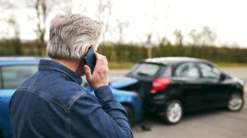 Foto de un hombre llamando por teléfono durante un accidente de tránsito