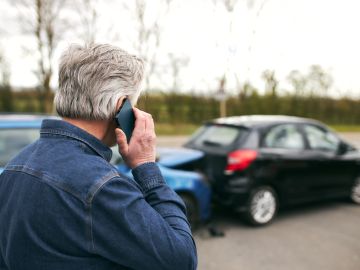 Foto de un hombre llamando por teléfono durante un accidente de tránsito