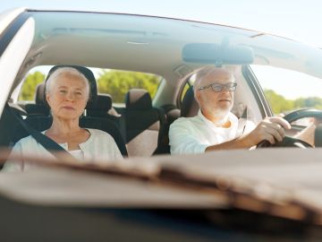 Foto de una pareja de ancianos en el interior de un vehículo.