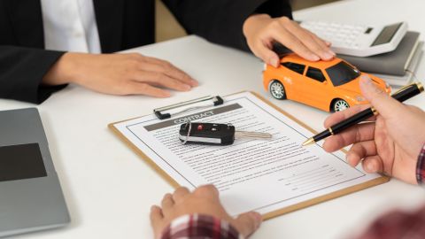 Foto de las manos de dos personas durante la firma de un contrato