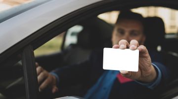 Foto de un hombre mostrando un hombre mostrando una licencia en blanco