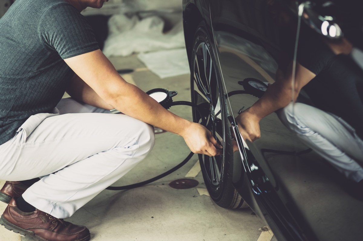 Photo of a man checking tire pressure