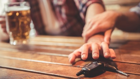 Foto de las manos de dos personas peleando por las llaves de un auto