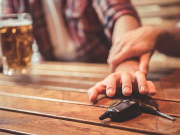 Foto de las manos de dos personas peleando por las llaves de un auto