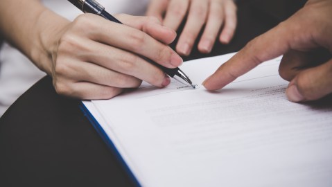 Foto de dos personas durante la firma de un documento