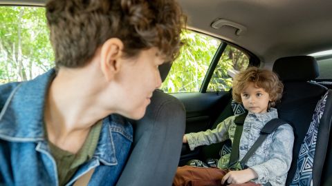 Niño sentado en el asiento trasero.