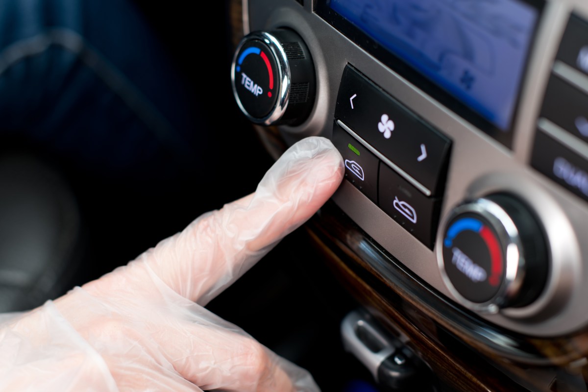 The air recirculation button is located in the vehicle's air conditioning system.