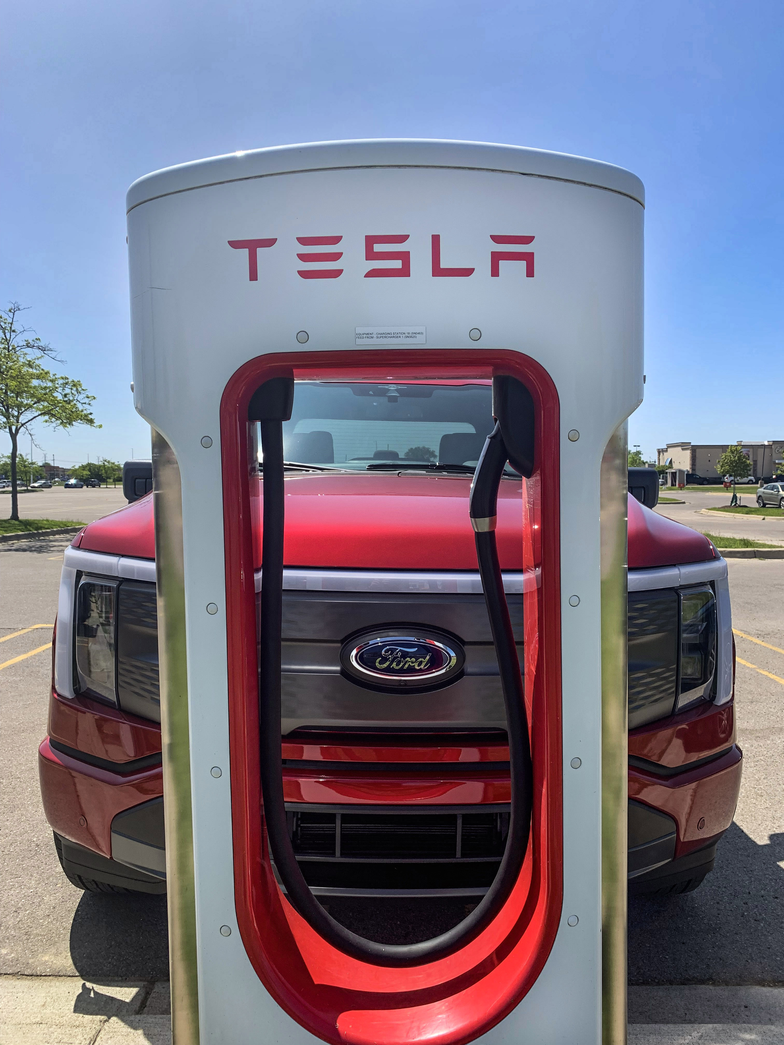 Un Ford F-150 Lightning en una estación de carga Tesla