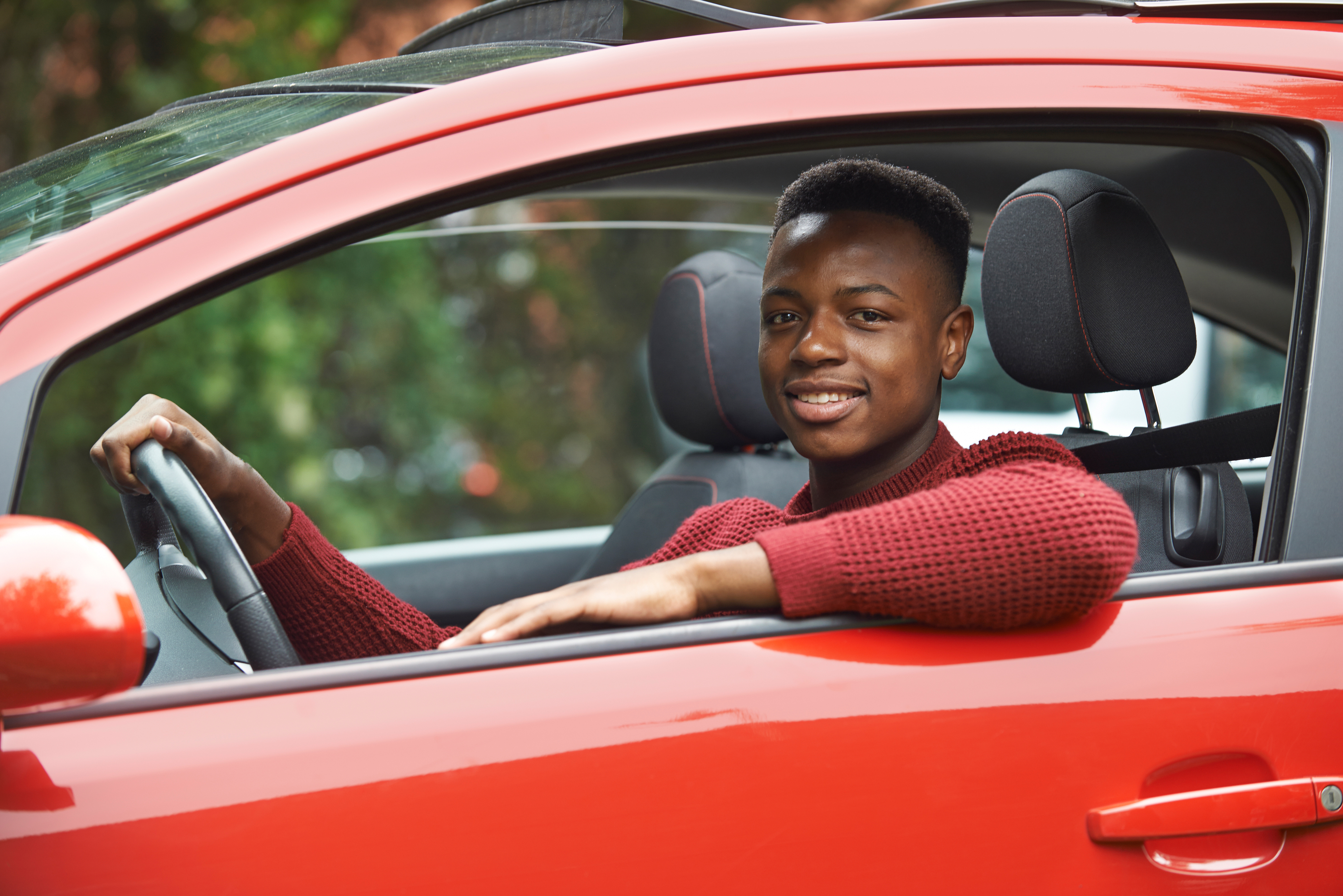 Male,Teenage,Driver,Looking,Out,Of,Car,Window