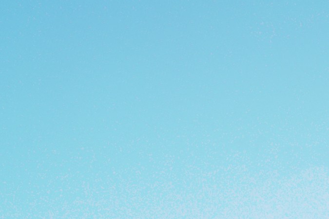 Hombre mirando el motor quemado del carro con capot abierto